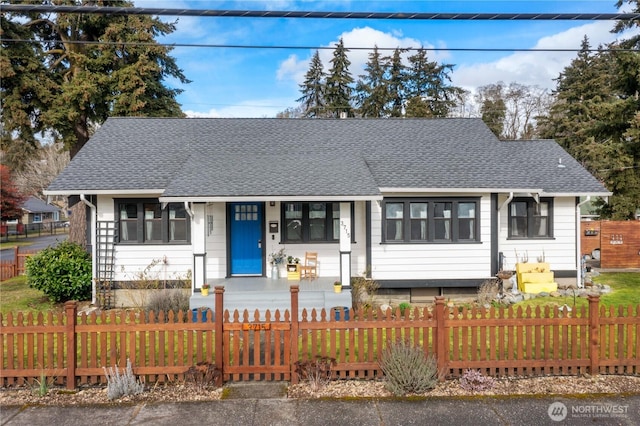 view of front of house featuring a fenced front yard and roof with shingles