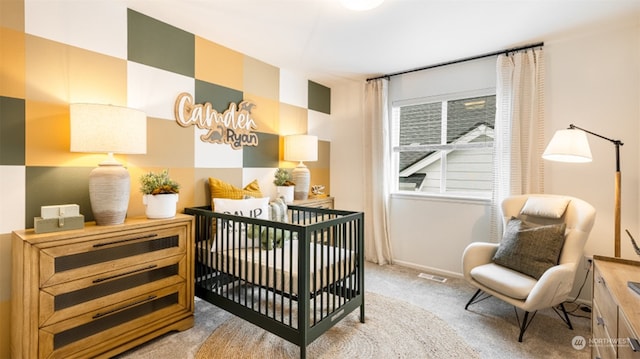 bedroom featuring a nursery area and carpet