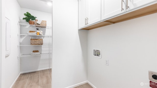 clothes washing area with washer hookup, cabinets, and hookup for an electric dryer