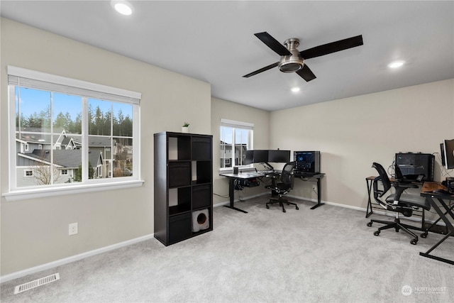 carpeted home office featuring ceiling fan