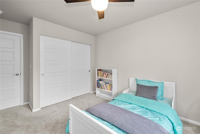 carpeted bedroom featuring a closet and ceiling fan