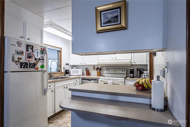 kitchen with white cabinetry, white appliances, kitchen peninsula, and sink