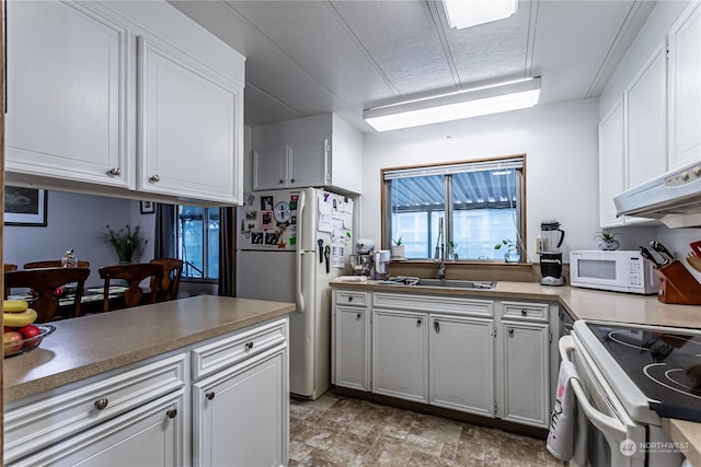 kitchen with white cabinetry, sink, a textured ceiling, and white appliances