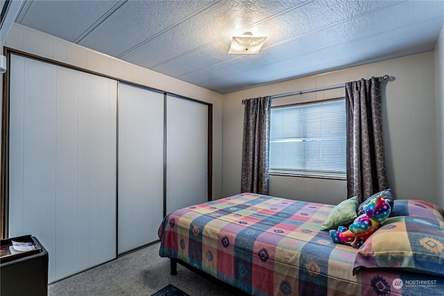 bedroom featuring carpet flooring, a textured ceiling, and a closet