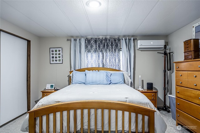 bedroom featuring a wall mounted AC and light carpet