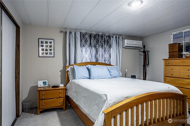 carpeted bedroom with an AC wall unit