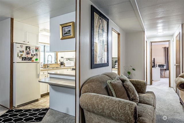 living room featuring sink and light carpet