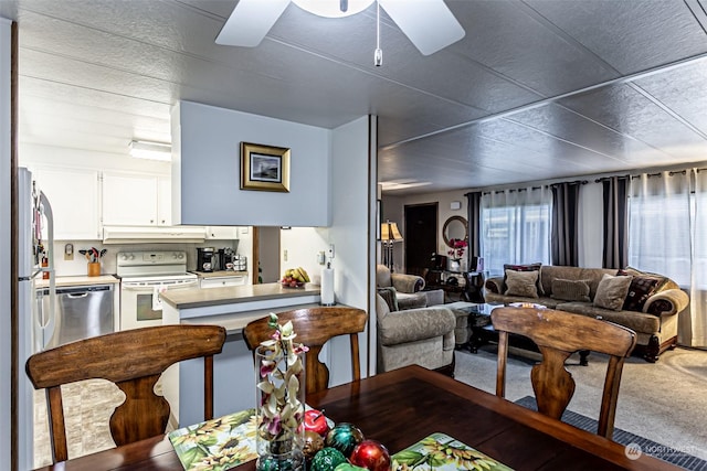 carpeted living room with ceiling fan