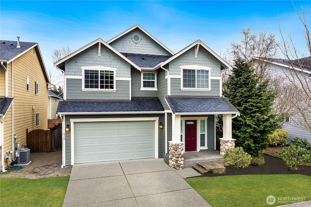 craftsman-style house featuring central air condition unit, a front yard, and a garage