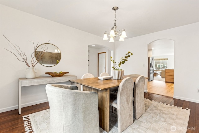 dining area with a notable chandelier and hardwood / wood-style floors