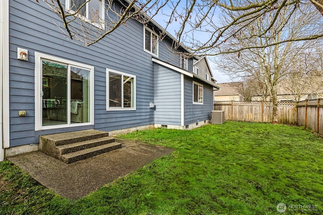 rear view of house featuring central air condition unit and a yard