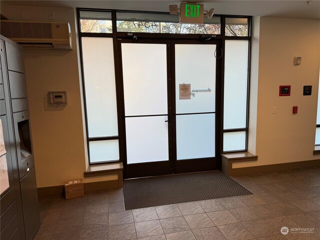 entryway featuring tile patterned floors, a wall mounted air conditioner, and plenty of natural light