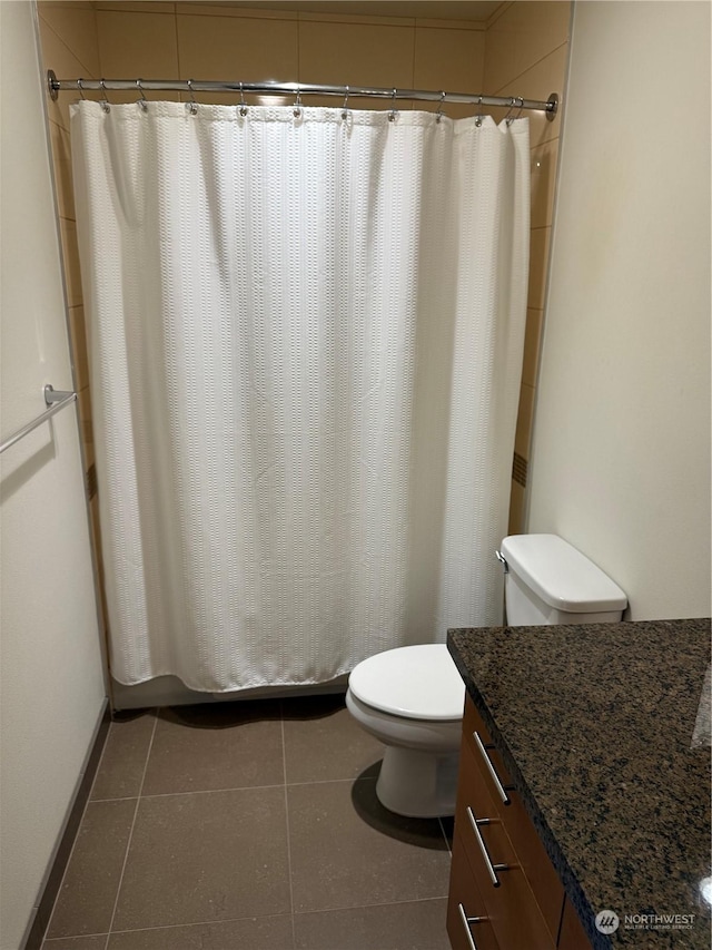 bathroom featuring toilet, vanity, tile patterned floors, and walk in shower