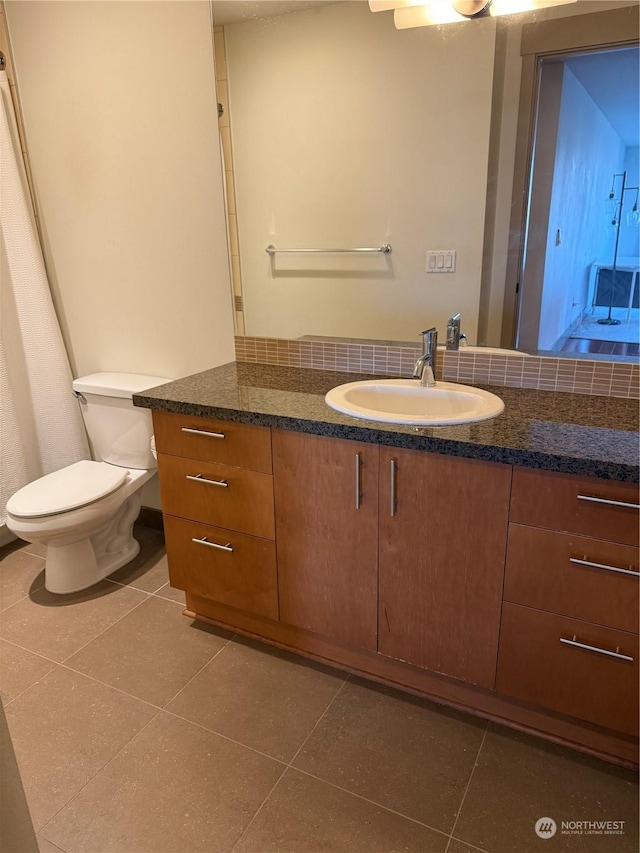 bathroom with tile patterned flooring, vanity, and toilet