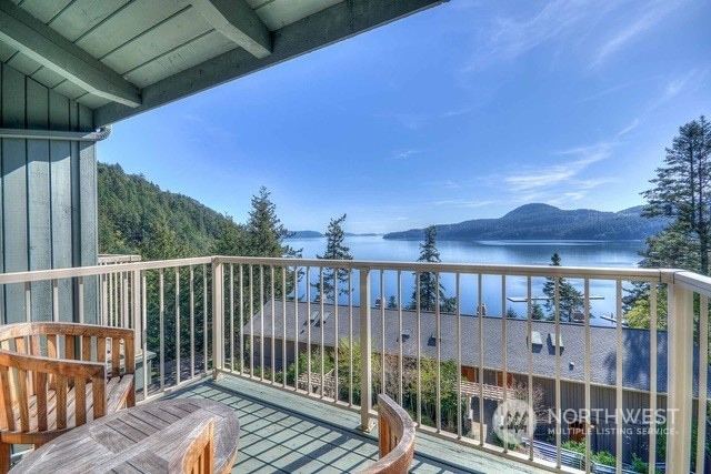 balcony featuring a water and mountain view