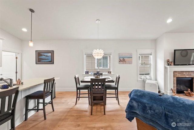 dining room with a fireplace and light wood-type flooring