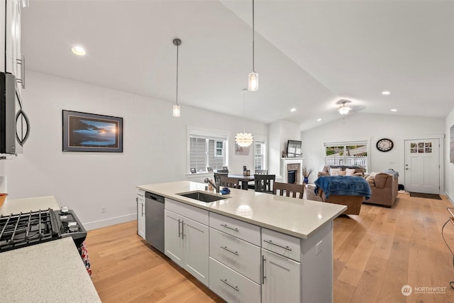 kitchen featuring sink, white cabinetry, light stone counters, pendant lighting, and appliances with stainless steel finishes