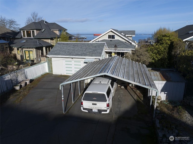 view of car parking with a carport and a water view