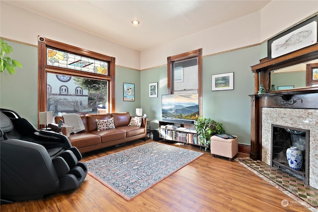 living room with light hardwood / wood-style floors and a tiled fireplace