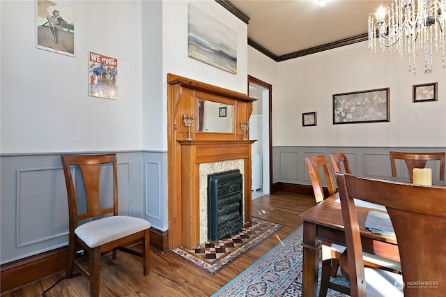 dining room featuring crown molding, dark hardwood / wood-style floors, a fireplace, and a notable chandelier