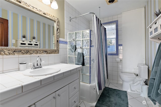 full bathroom with toilet, tile walls, tile patterned floors, shower / bath combo, and vanity