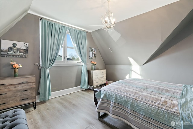 bedroom featuring an inviting chandelier, light hardwood / wood-style flooring, and vaulted ceiling