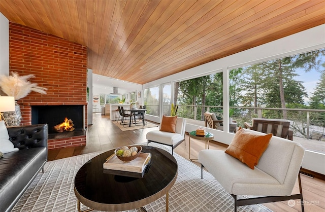 sunroom featuring a brick fireplace, wooden ceiling, and lofted ceiling