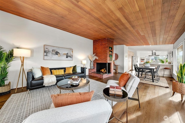 living room featuring wood-type flooring, wooden ceiling, and a fireplace