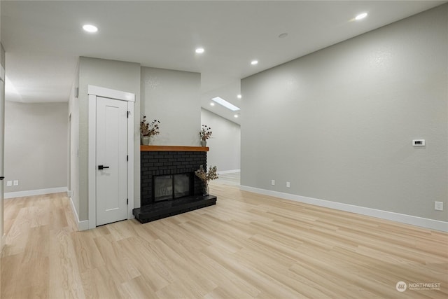 living room with a fireplace and light hardwood / wood-style flooring