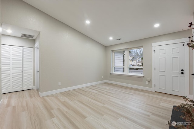 unfurnished bedroom with lofted ceiling and light hardwood / wood-style flooring