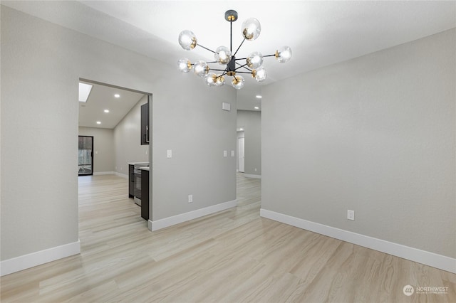 unfurnished dining area with light hardwood / wood-style floors and a chandelier