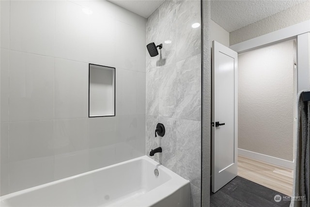 bathroom featuring hardwood / wood-style flooring and tiled shower / bath