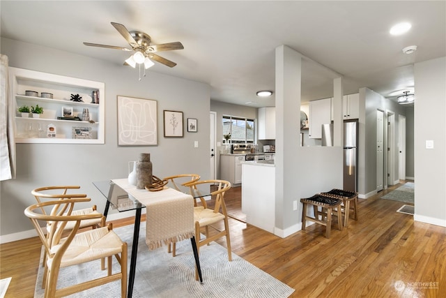 dining room featuring built in features, light wood-type flooring, and ceiling fan