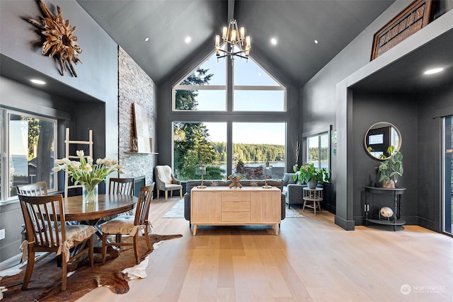 dining room with a notable chandelier, light hardwood / wood-style floors, and high vaulted ceiling