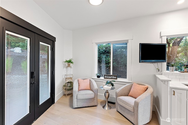 living area featuring light hardwood / wood-style floors and french doors