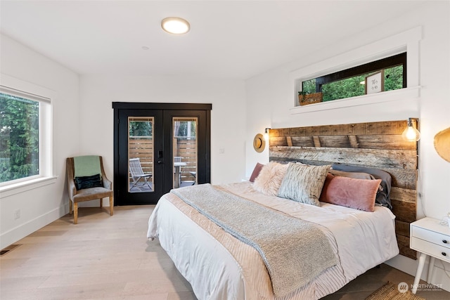 bedroom with access to outside, french doors, and light hardwood / wood-style floors