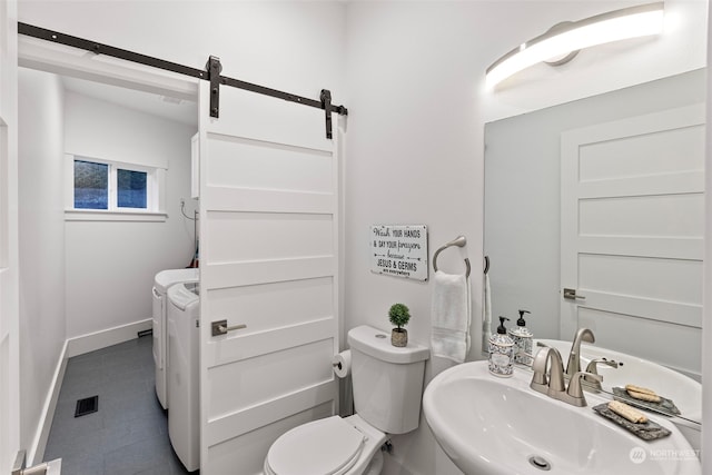 bathroom with toilet, sink, and independent washer and dryer