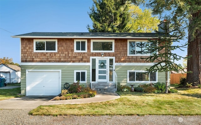 raised ranch featuring a front lawn and a garage