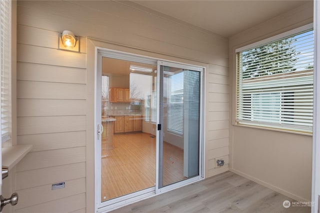 interior space with light hardwood / wood-style floors and wood walls