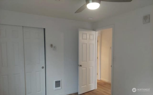 unfurnished bedroom with ceiling fan, light hardwood / wood-style floors, and a closet