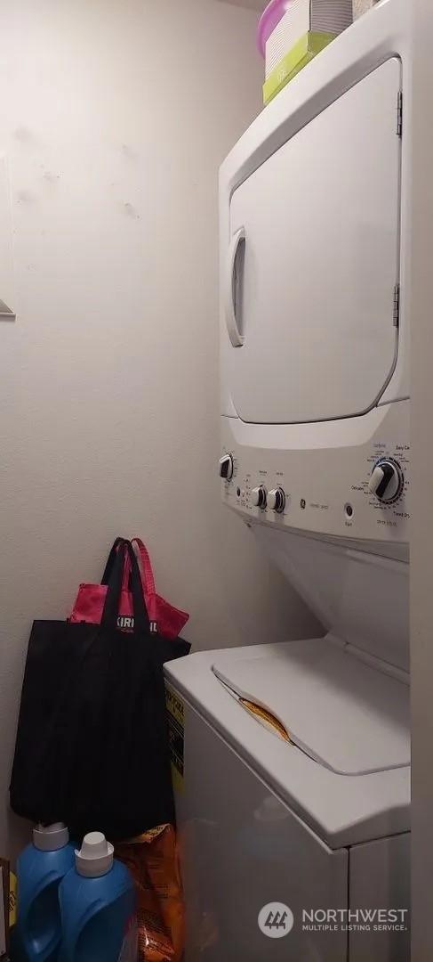 laundry room with stacked washing maching and dryer