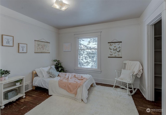 bedroom featuring dark hardwood / wood-style flooring, a spacious closet, and a closet