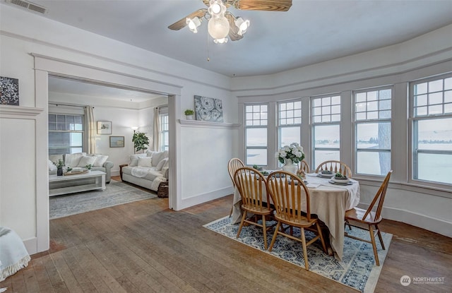 dining space featuring a water view, ceiling fan, and hardwood / wood-style floors