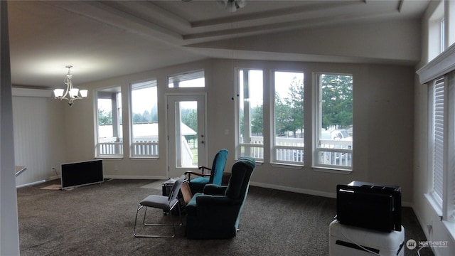 sitting room with a healthy amount of sunlight, an inviting chandelier, and carpet flooring