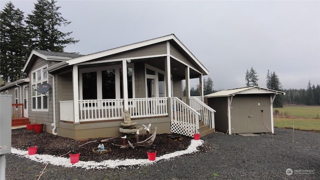 view of front of property with a porch and a shed