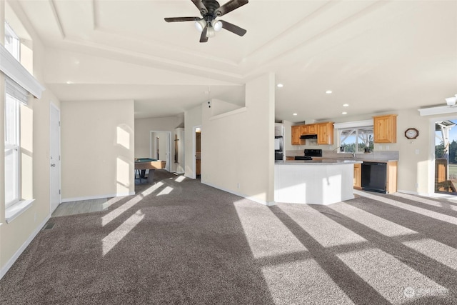 unfurnished living room featuring a raised ceiling and light carpet