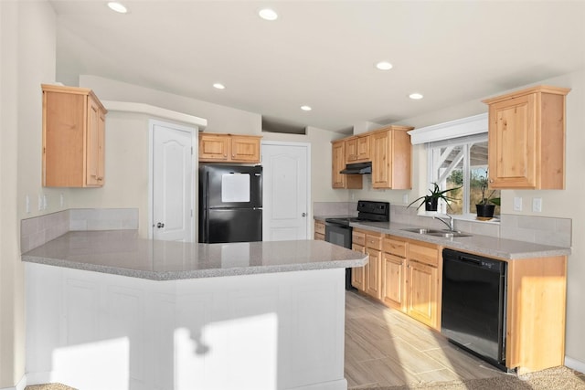 kitchen featuring vaulted ceiling, black appliances, kitchen peninsula, sink, and light brown cabinetry