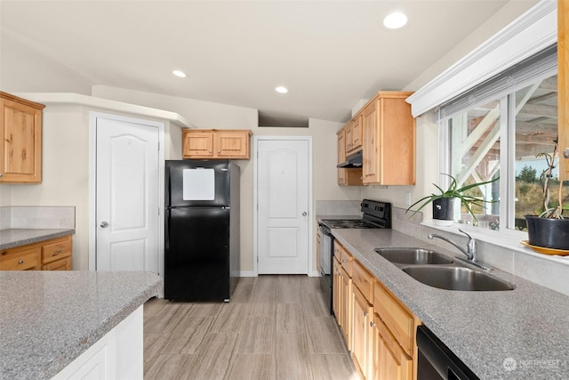 kitchen featuring vaulted ceiling, light brown cabinetry, sink, and black appliances