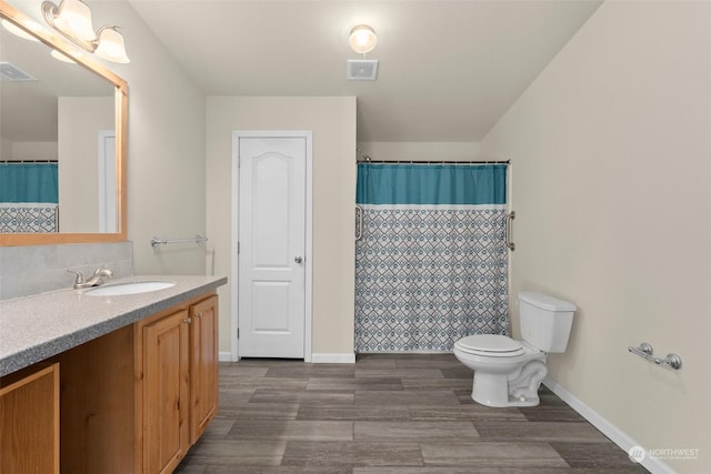 bathroom featuring toilet, walk in shower, hardwood / wood-style flooring, and vanity