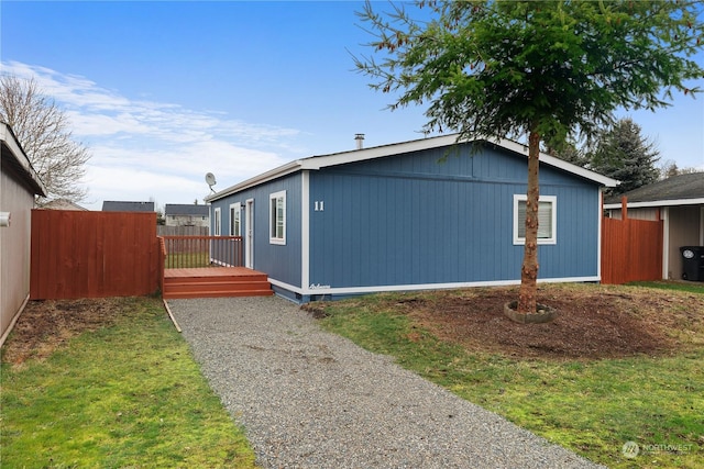 view of home's exterior with a deck and a lawn